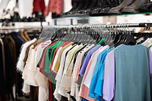 T-shirts and blouses hanging on clothes rack photo