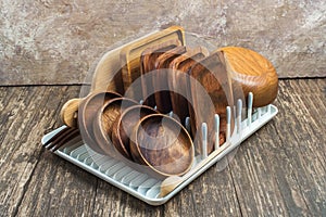 Variety of wooden utensils after washing on a drying stand on a wooden table. Healthy food concept