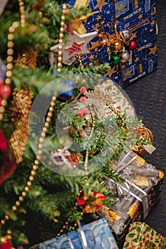 A variety of wrapped gifts under a festively decorated Christmas tree. Life style