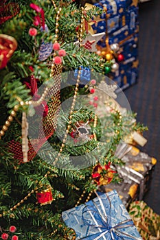 A variety of wrapped gifts under a festively decorated Christmas tree. Life style