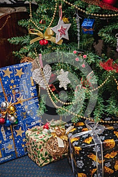 A variety of wrapped gifts under a festively decorated Christmas tree. Life style