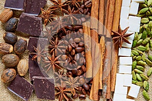 Various aromatic spices star anise, cinnamon, nutmeg, sugar cubes, coffee beans, chocolate close up. Ingredients for spicy tea