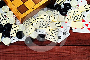 Various board games chess board, playing cards, dominoes.