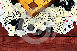 Various board games chess board, playing cards, dominoes.