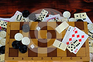 Various board games chess board, playing cards, dominoes.