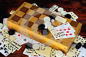 Various board games chess board, playing cards, dominoes.