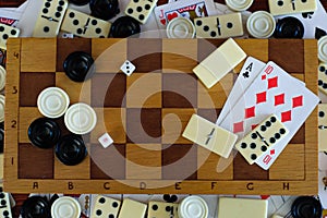 Various board games chess board, playing cards, dominoes.