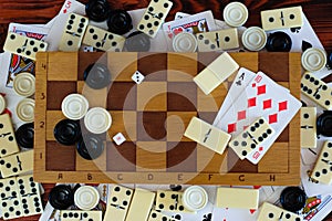 Various board games chess board, playing cards, dominoes.