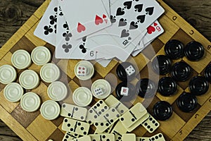 Various board games chess board, playing cards, dominoes.