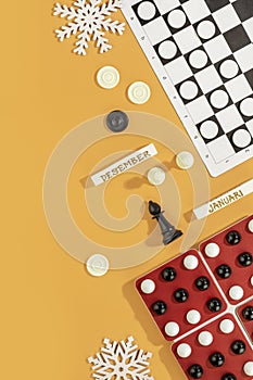 Various board games on an orange background with Christmas decoration