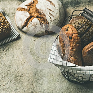 Various bread loaves on grey concrete background, square crop