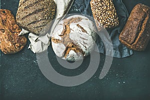 Various bread selection flat-lay, black background, copy space