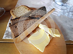 Various of bread, whole grain with butter and wooden knife on wooden board on the table