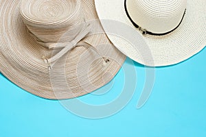 Various broad brimmed women`s straw hats on light mint blue background. Summer vacation fashion accessories beach photo