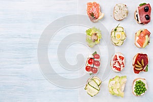 Various canapes on parchment paper on a wooden blue background