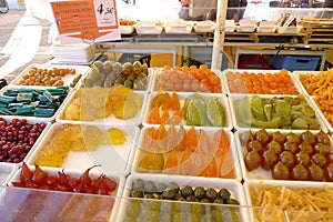 Various candies sold in the market in Nice, France, such as oranges, pomegranates, melons, and figs