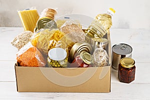 Various canned food, pasta and cereals in a cardboard box