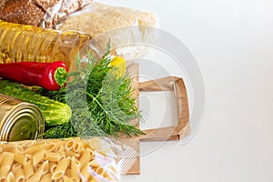 Various canned food, pasta and cereals in a cardboard box. Food donations or food delivery concept