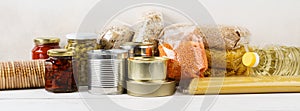 Various canned food and raw cereal grains on a table