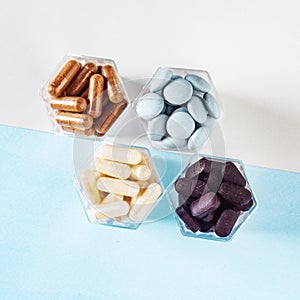 Various capsules with dietary supplements or medicines in honeycomb form jars
