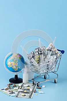 Various capsules, tablets and medicine in shop trolley with geographic globe