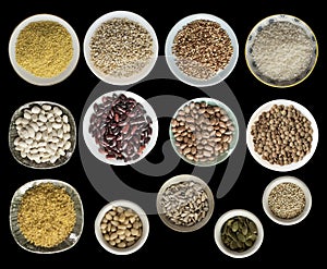 Various cereals, seeds, beans, peas on plates isolated on black background, top view.