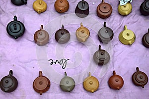 Various chinese clayware tea pots in the violet background. photo