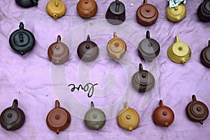 Various chinese clayware tea pots in the violet background.