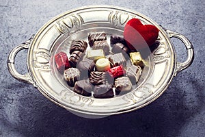Various chocolate on antique silver plate for valentine`s day
