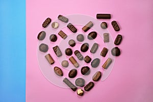 Various chocolate candies isolated on pink background. Saint Valentines day concept