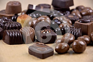 Various chocolate pralines on a brown background stock images