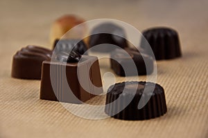 Various chocolate pralines on a brown background stock images