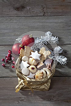 Various Christmas cookies in golden sacket on wooden background