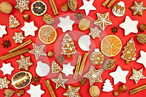 various christmas gingerbread cookies with spices on red background