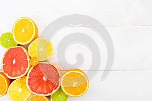 Various citrus fruit on the white wooden background