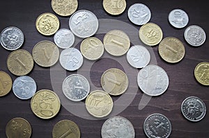 Various coins collection on old wooden table