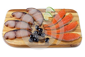 Various cold smoked fish slices: sturgeon, tuna with olives on wooden board isolated