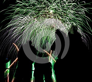 Various colored fireworks with silhouette of people.