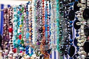 Various colorful beads in the market. Wallpaper background of a colorful necklace made of precious stones and colored beads.