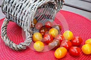 Various of colorful cherry tomatoes in wicker basket.