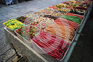 Various colorful jelly sweets and confectionary exposed in plastic boxes for sale in the street. Contrasting colors of candies and