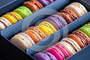 Various colorful macarons or French macaroons in a row in a gift box