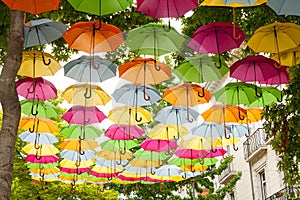 Various colorful umbrellas hanging in the air.