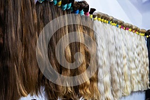 Various colors of hair extensions showcased, hanging neatly in a row