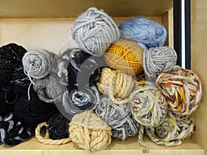 Various colors wool yarns and balls on the shelf