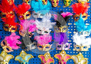 Various, colourful Venetian masks with feathers, souvenirs