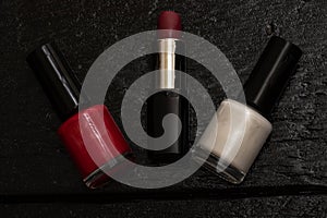 Various cosmetics on a black background nail polish, lipstick. Close up photo