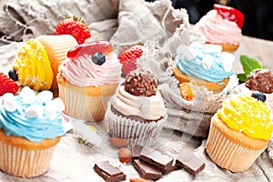 Various cupcakes on canvas. On a wooden table