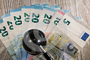 Various denomination euros with stethoscope bell on top