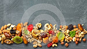 Various dried fruits and mix nuts on a gray stone or slate background.  The concept of the Jewish holiday Tu Bishvat. Flat lay,